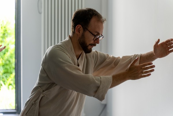 Ein Mann in traditioneller Sportkleidung hält eine entspannte Pose