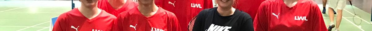 Sieben Personen in roter Sportkleidung mit Badmintonschlägern in der Hand