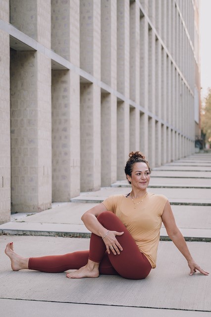 Eine Frau in Sportkleidung macht eine Yoga-Übung auf einer Sportmatte