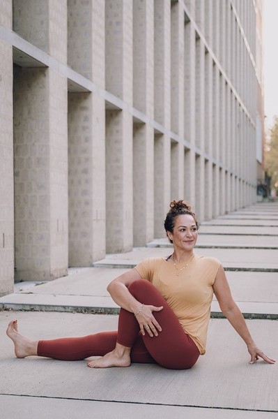 Eine Frau in Sportkleidung macht eine Yoga-Übung auf einer Sportmatte