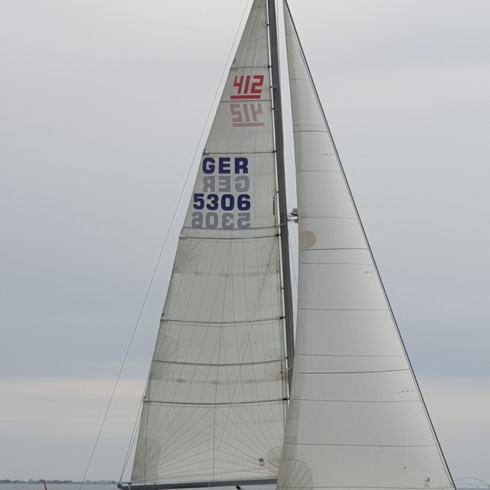 Ein Segelboot in Fahrt mit 4 Personen darauf (vergrößerte Bildansicht wird geöffnet)