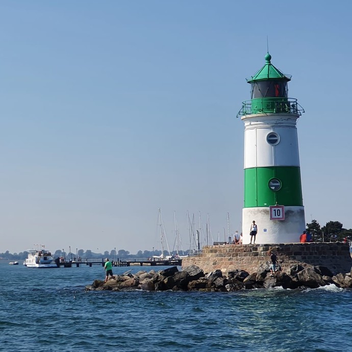 Grün-weißer Leuchtturm auf einem Felsen (vergrößerte Bildansicht wird geöffnet)